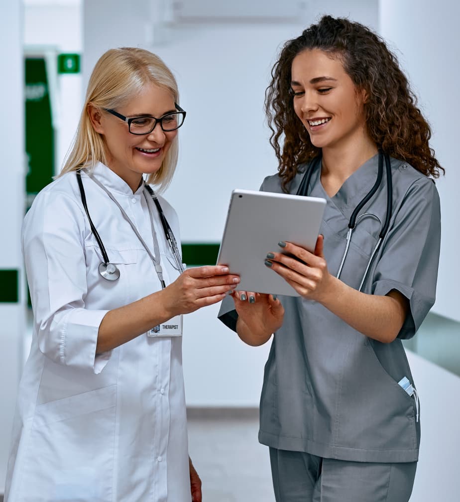 female medical student reviewing chart on ipad with attending physician
